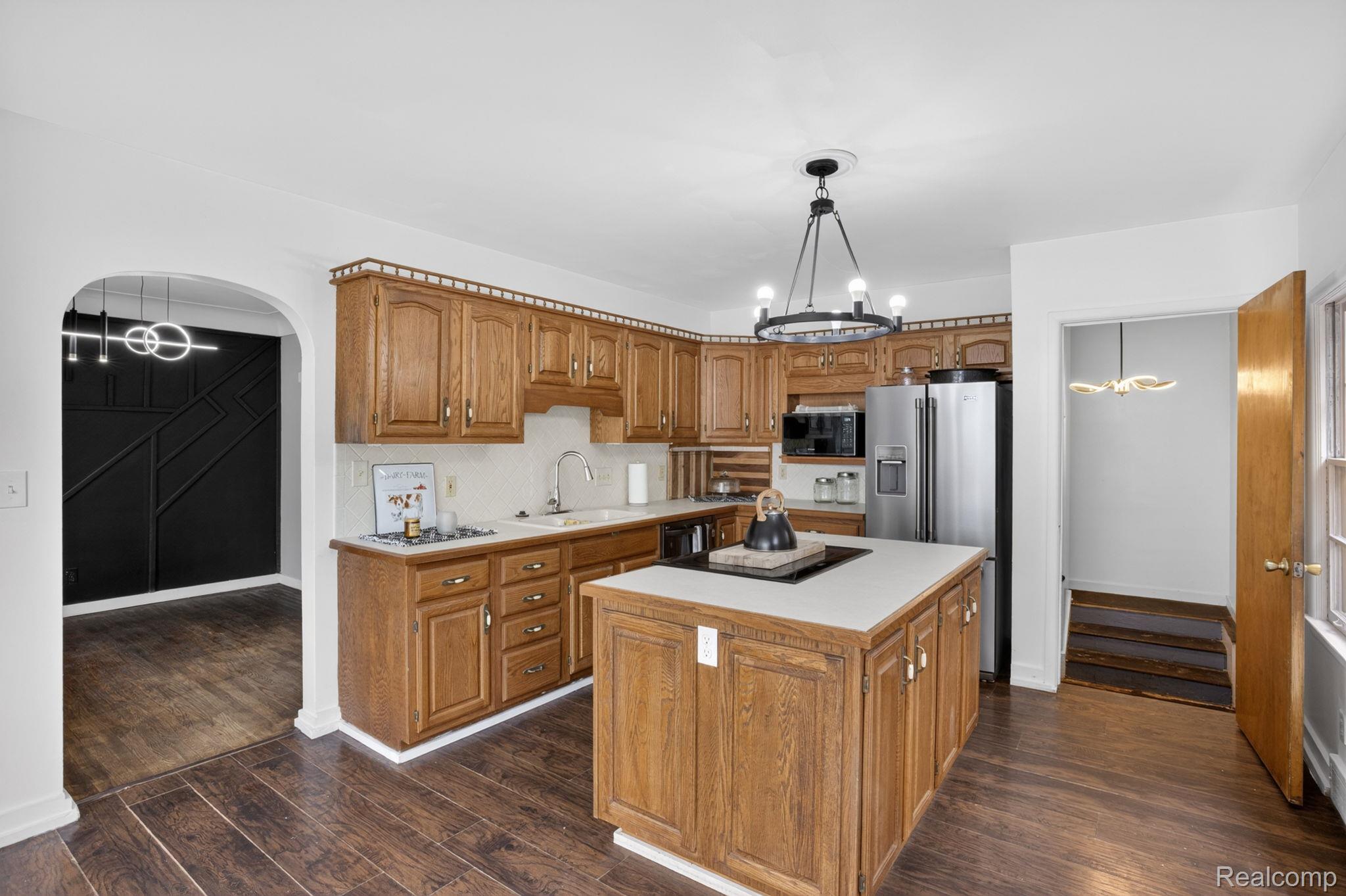 1209 Beatrice Street Flushing, MI 48433 - Photo 7 of 39 Kitchen with hanging lights, wood finish cabinetry, and light countertops