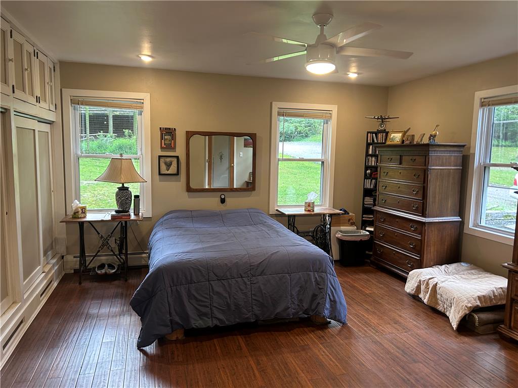 7 Allegheny Road Mount Bethel, PA 18343 - Photo 48 of 71 Rich wood flooring runs throughout this bedroom flanked by multiple windows and built-in storage units.