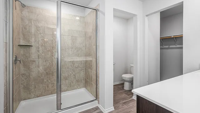 a bathroom with a granite countertop toilet a sink and shower