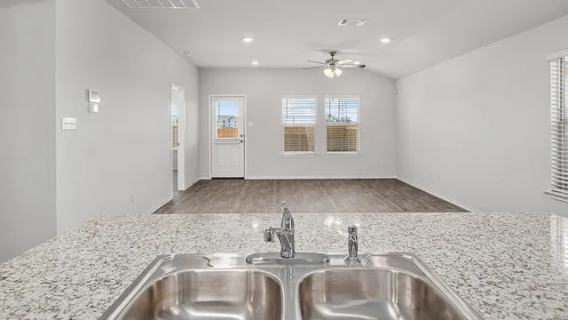 a view of a kitchen sink and dishwasher with wooden floor