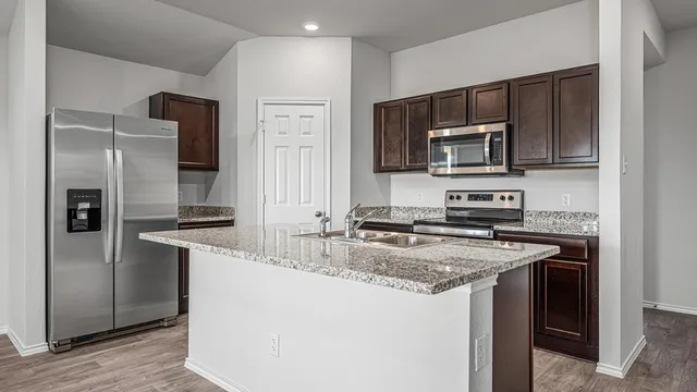 a kitchen with stainless steel appliances granite countertop a sink stove and refrigerator