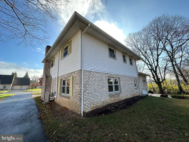 a view of a house with backyard and trees