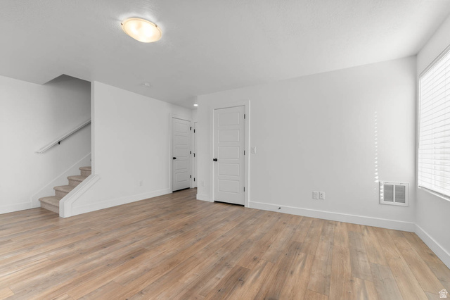 8307 Durham Street Sandy, UT 84070 - Photo 25 of 29 Spacious room featuring wood-finish flooring, white walls, and a recessed window with blinds