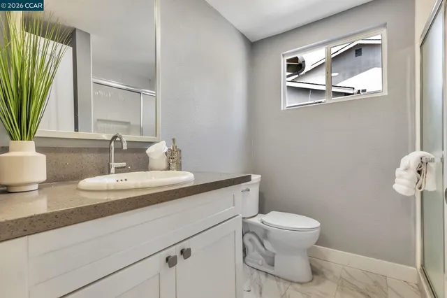 a bathroom with a toilet a sink and mirror