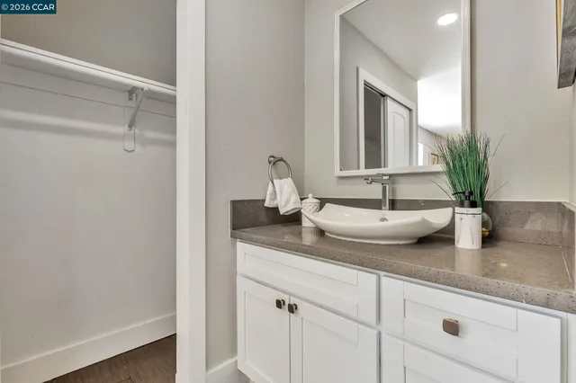 a bathroom with a granite countertop sink and a mirror
