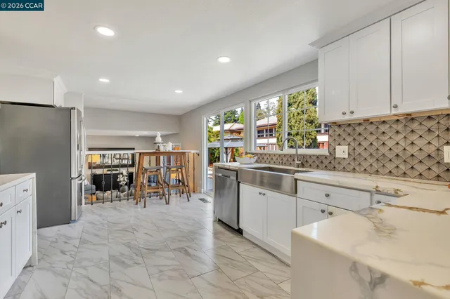 a kitchen with stainless steel appliances granite countertop a refrigerator and a sink