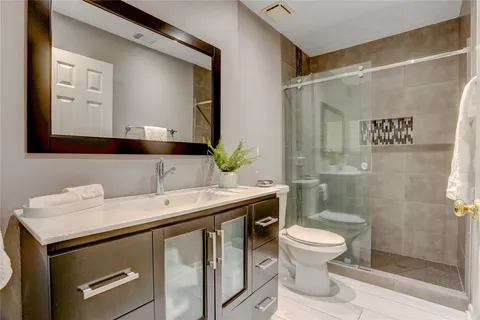 a bathroom with a sink a toilet and shower