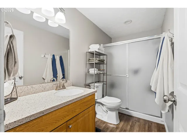 a bathroom with a sink a toilet a mirror and shower