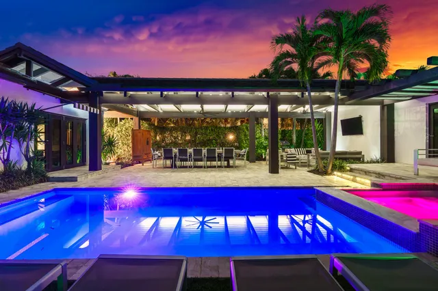 a view of swimming pool with red chairs