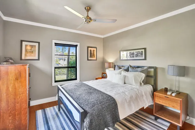 a kitchen with stainless steel appliances kitchen island granite countertop a stove a sink a refrigerator white cabinets with wooden floor