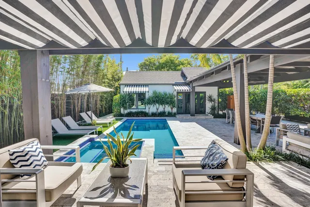 a dining room with furniture a chandelier and wooden floor