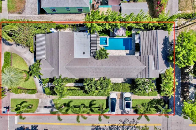 an aerial view of a house with a yard and a large pool
