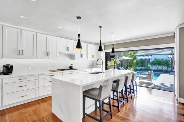 a kitchen with a table chairs and white cabinets