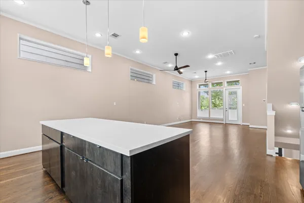 an empty room with windows and fan