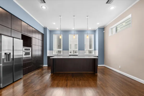 a kitchen with stainless steel appliances granite countertop a sink a stove and a refrigerator