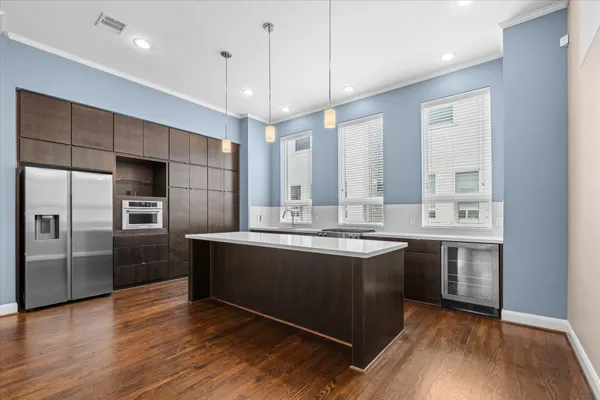 a view of kitchen with granite countertop a sink dishwasher a refrigerator and wooden floor
