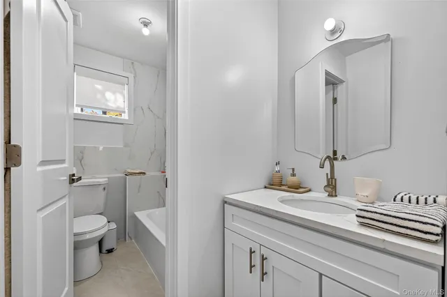 a bathroom with a toilet a sink and mirror
