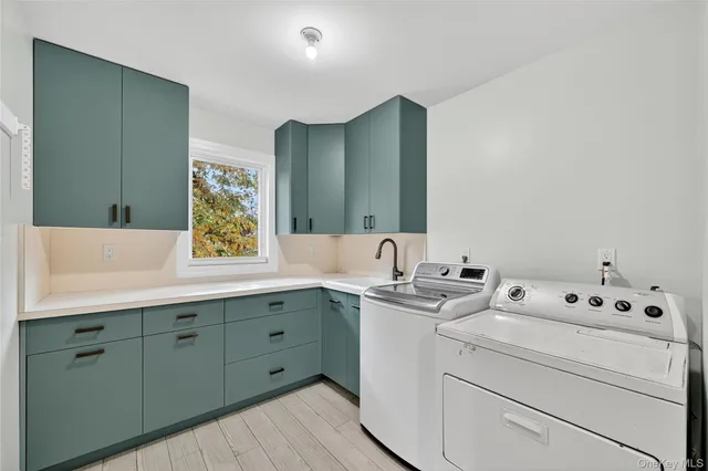 a utility room with cabinets washer and dryer