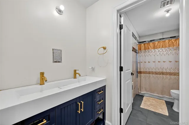 a en suite bathroom with a double vanity sink a toilet and shower