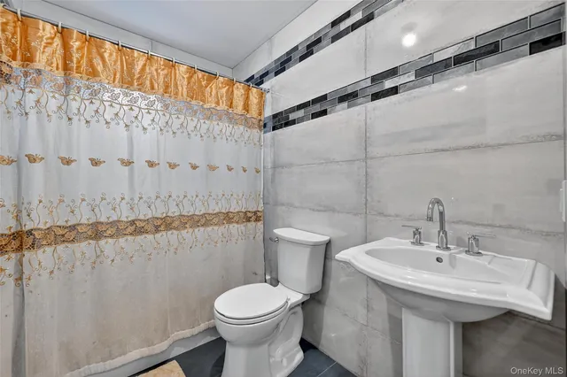 a bathroom with a sink a toilet and shower curtain