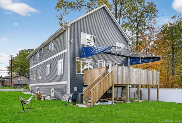 a view of an house with backyard and a tree