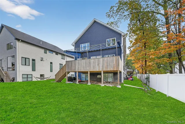 a view of a house with a yard and large tree
