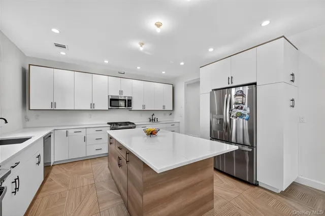a kitchen with stainless steel appliances a refrigerator sink and microwave
