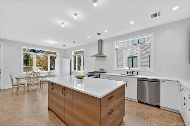 a kitchen with a stove a sink a refrigerator and chairs