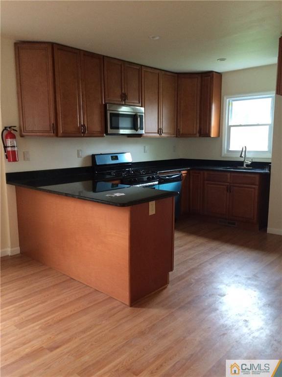 534 Chain O' Hills Road Colonia, NJ 07067 - Photo 2 of 6 a kitchen with granite countertop wooden cabinets and a wooden floor