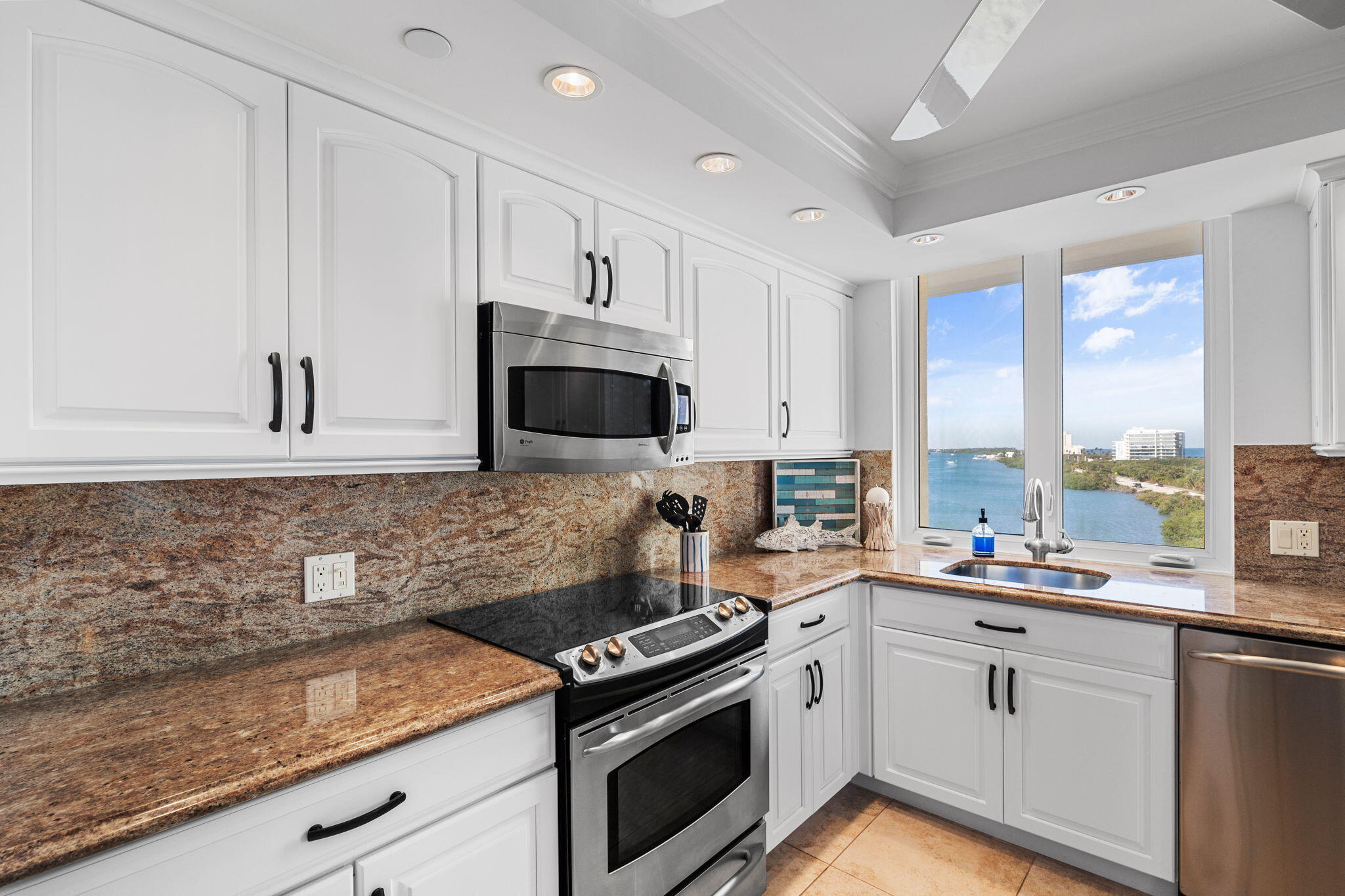 375 South Beach Road, Unit 802 Tequesta, FL 33469 - Photo 14 of 39 a kitchen with stainless steel appliances granite countertop a sink a stove and a microwave