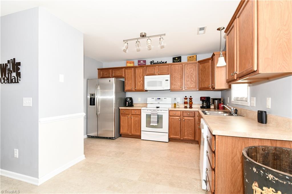 467 Ansley Way High Point, NC 27265 - Photo 5 of 16 The kitchen is made for entertaining and cooking. White appliances (oven/range brand new), oak cabinetry, window sink with pendant light, pantry, ambient track lighting, chair rail molding, brand new flooring.