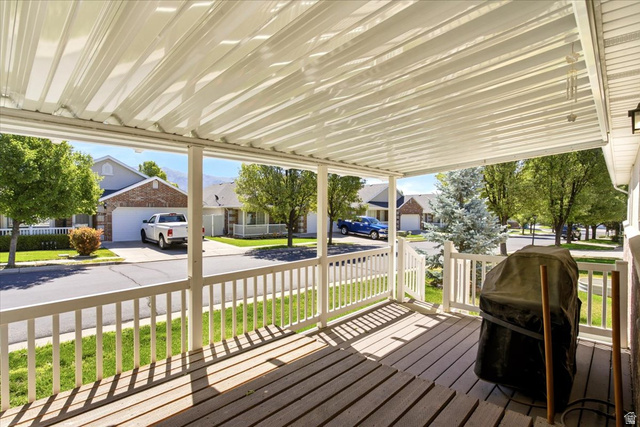 1089 West 2325th Street North Layton, UT 84041 - Photo 39 of 40 Covered outdoor patio featuring a slatted wood-finish deck, white railing, and a corrugated metal roof