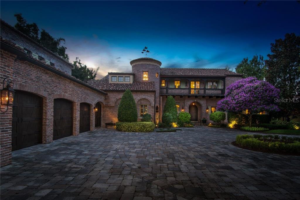 Front Elevation at dusk, featuring oversized motor court and gas lanterns.