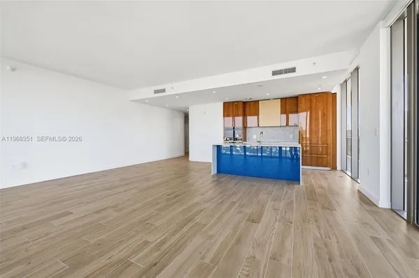 a view of a room with wooden floor and a window