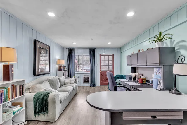 a living room with furniture flat screen tv and window