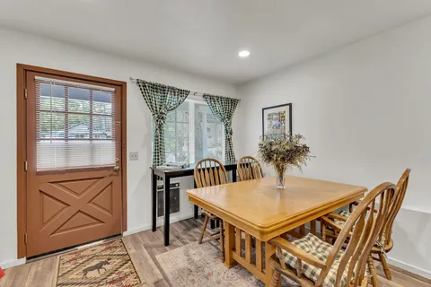 a balcony view with table and chairs and wooden floor with potted plants