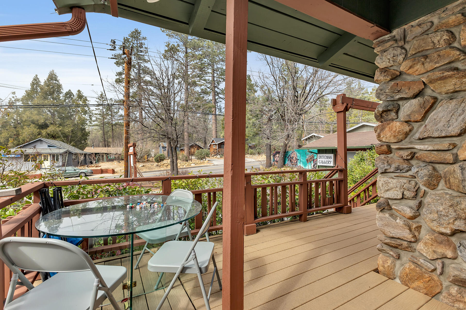 54585 North Circle Drive Idyllwild, CA 92549 - Photo 36 of 58 a balcony view with table and chairs and wooden floor with potted plants