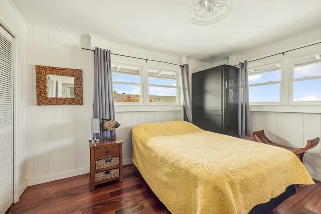 a bed sitting in a bedroom next to a window