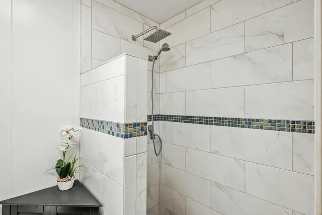 a bathroom with a shower and a potted plant