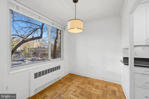 a view of a big room with wooden floor and windows