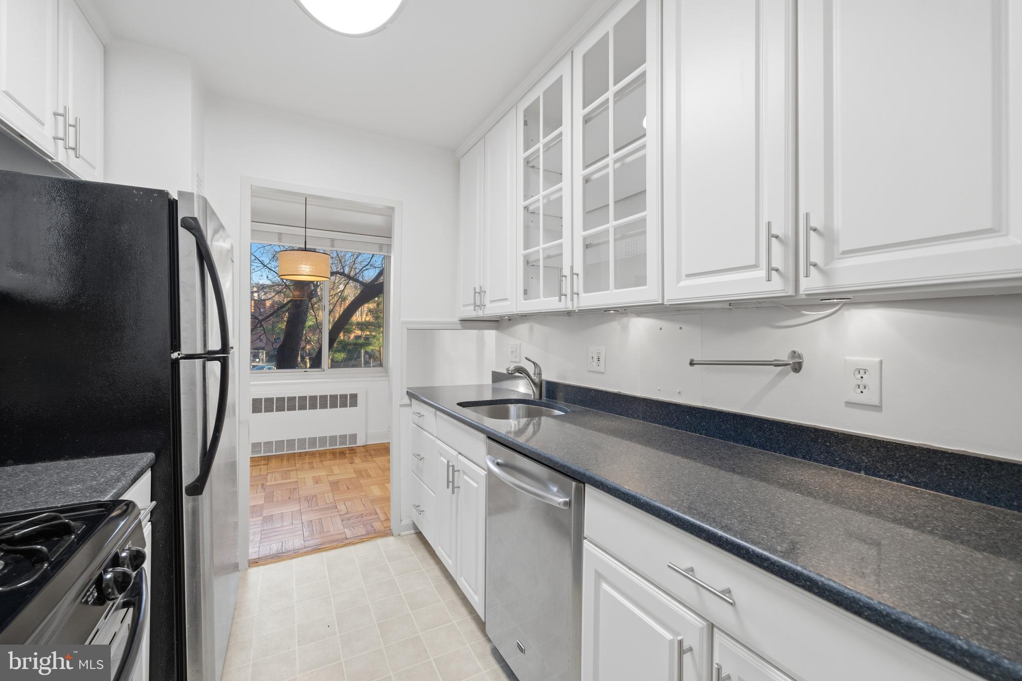 4000 Tunlaw Road Northwest, Unit 220 Washington, DC 20007 - Photo 19 of 30 a kitchen with stainless steel appliances granite countertop a sink stove and refrigerator