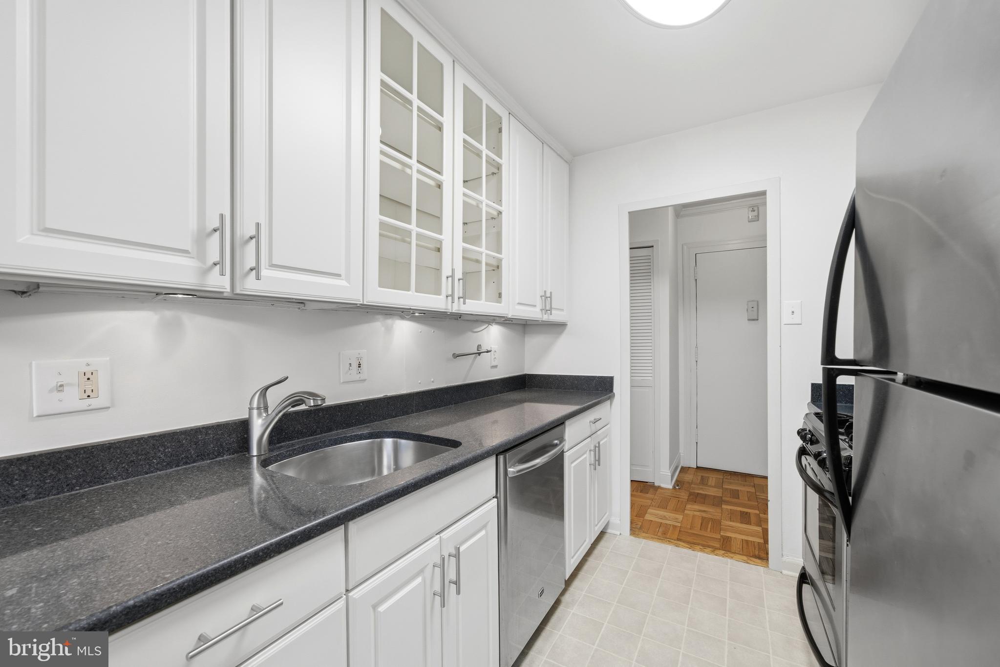 4000 Tunlaw Road Northwest, Unit 220 Washington, DC 20007 - Photo 21 of 30 a kitchen with stainless steel appliances granite countertop a refrigerator and a sink