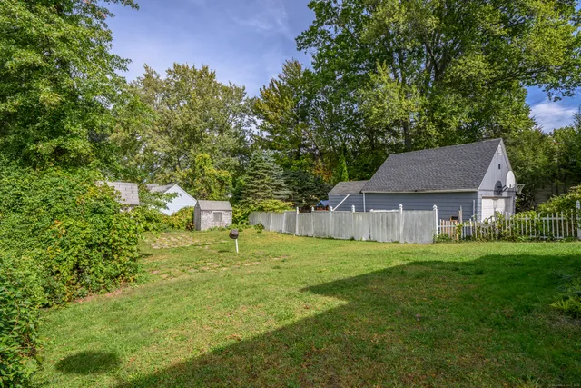 a backyard of a house with table and chairs