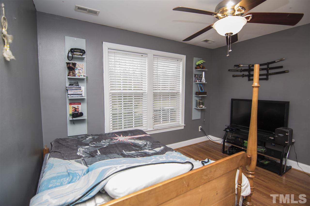 2420 Rolling Tracks Road Willow Spring, NC 27592 - Photo 14 of 25 a bed sitting in a bedroom next to a window