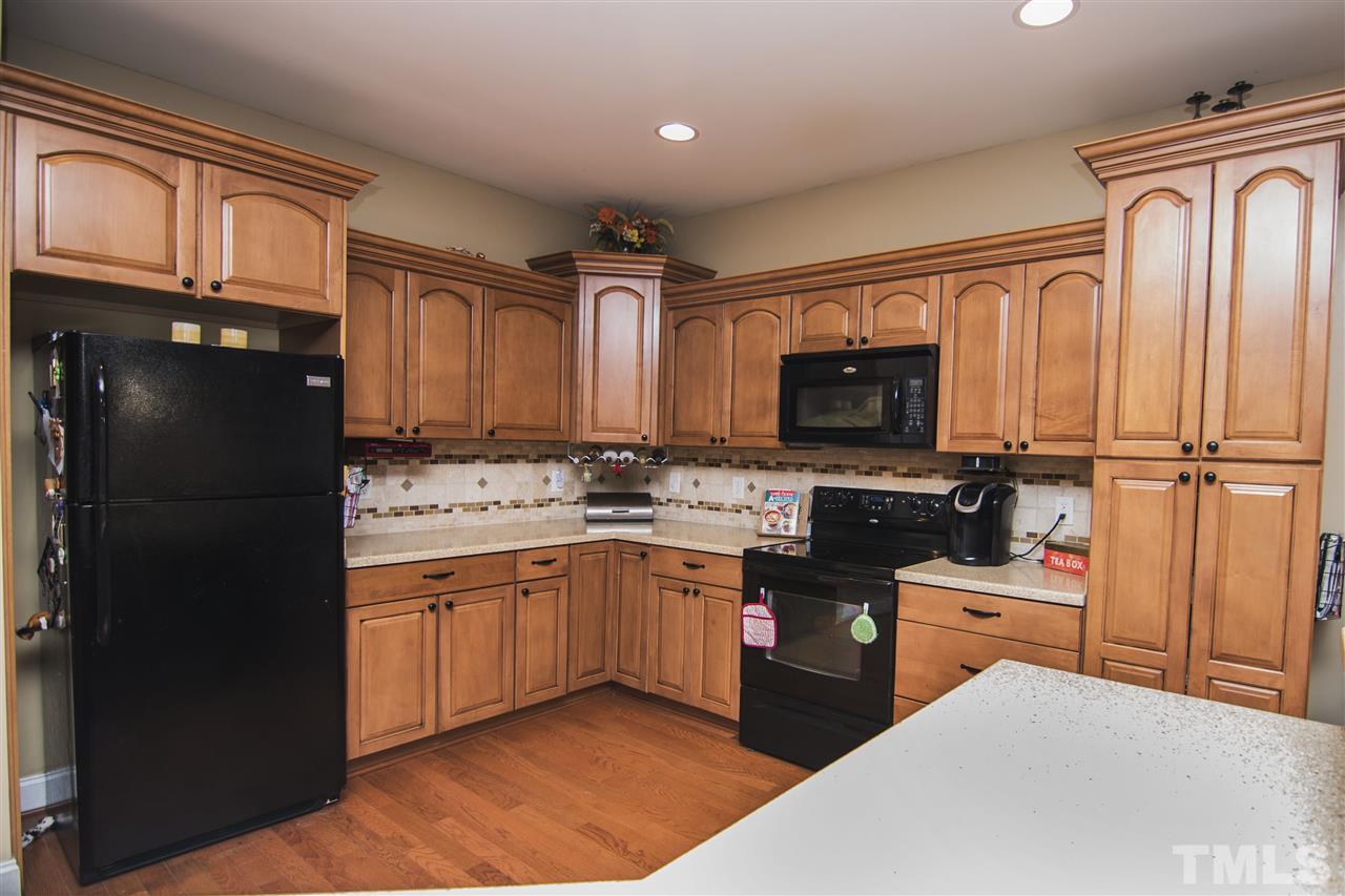 2420 Rolling Tracks Road Willow Spring, NC 27592 - Photo 8 of 25 a kitchen with granite countertop a refrigerator stove and sink