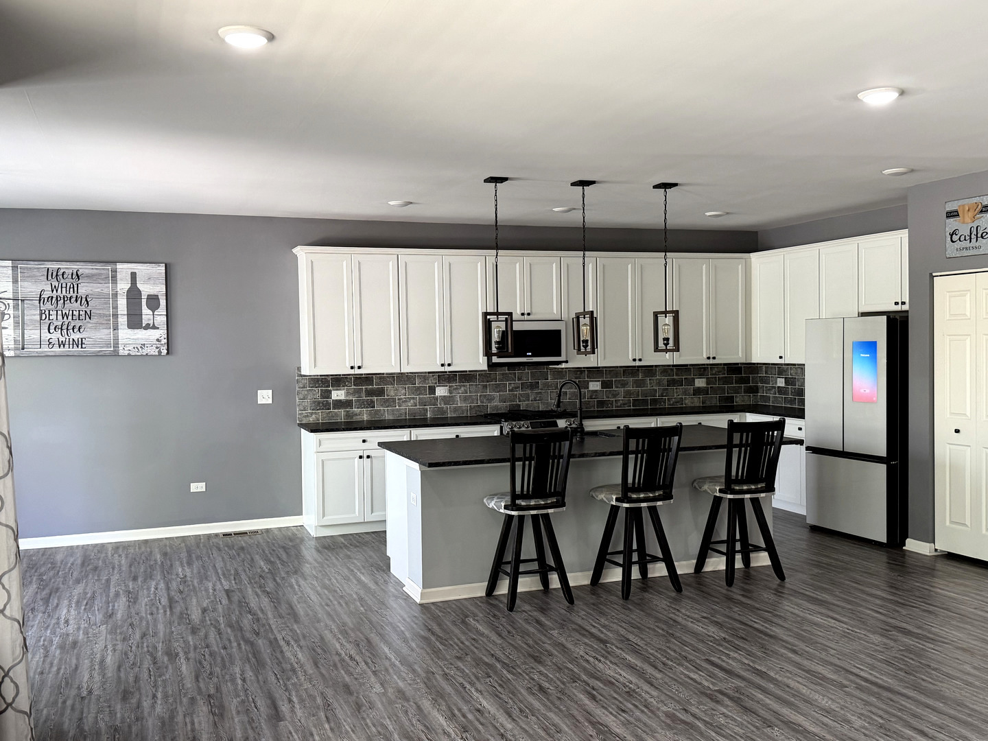 713 Long Ridge Trail Minooka, IL 60447 - Photo 18 of 40 a kitchen with stainless steel appliances a table chairs refrigerator and cabinets