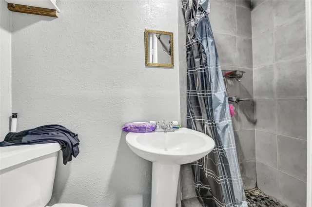 a bathroom with a sink toilet and shower