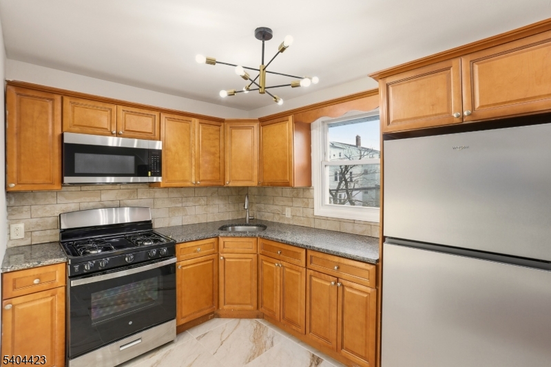112 University Place Irvington, NJ 07111 - Photo 12 of 31 a kitchen with stainless steel appliances granite countertop a refrigerator a stove a sink and a microwave
