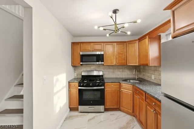 a kitchen with stainless steel appliances granite countertop a stove and a microwave