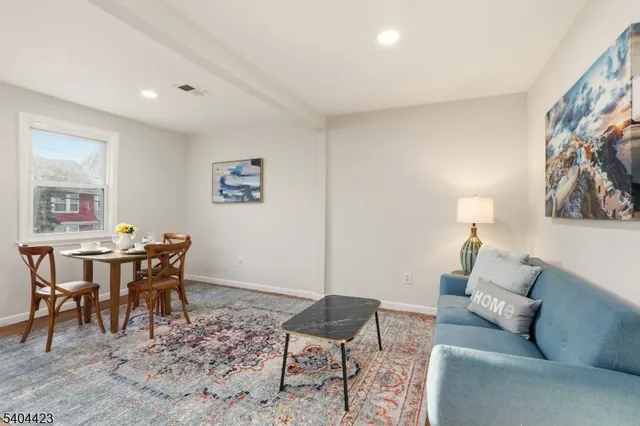 a living room with furniture and a dining table with rug